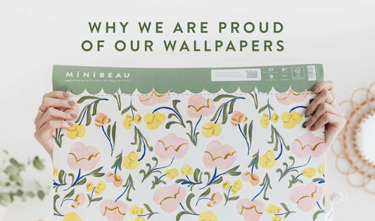 Hands holding our floral wallpaper with WHY ARE WE PROUD OF OUR WALLPAPERS written above in green