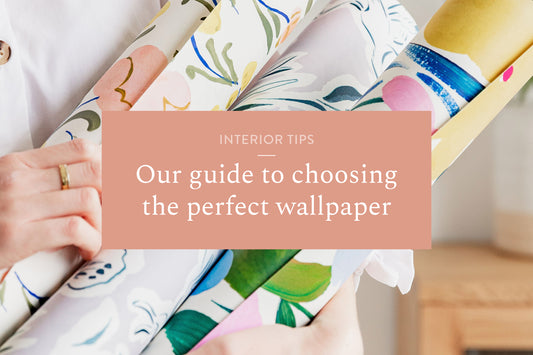 Image of someone holding rolls of wallpaper with interior tips - our guide to choosing the perfect wallpaper in a box in the middle