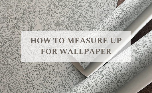 Garden Doodles wallpaper laying flat with some cut lengths rolling up on top with the words HOW TO MEASURE UP WALLPAPER in a faded white box
