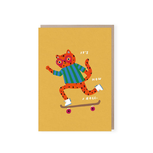 Yellow card with an orange spotty cat wearing round red glasses, and a blue and green vertically striped jumper and white and blue high tops, riding on a brown skateboard with the words "it's how I roll" in white. Comes with a brown kraft envelope