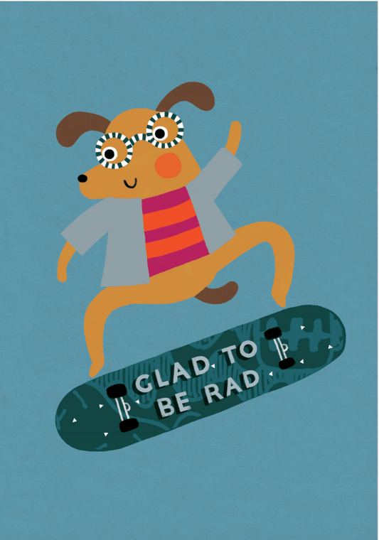 Dusty blue card with a brown dog wearing round white and blue stripey glasses, a orange and purple horizontal striped top with a grey open jacket, riding a dark green skateboard with the words "Glad to be rad" written on the bottom. Comes with a brown kraft envelope