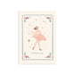 Picture of an art print showing a ballerina called Alicia in a graceful pose on an off white background surrounded by gold stars with the magic is in you written underneath her. surounded by a thin blue wavy border with red dots either side and flowers and foliage delicately sitting in each corner