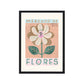 Art print in a black frame. Our Mercado de Flores art print drawn in a vintage style features alarge cream flower with pink and blue veins and 2 leaves on the stem on a pink background. With MERCADO DE on a blue background, and  FLORES on a cream background, in large font and LA VIDA ES BELLA in small text on a terracotta and cream background.