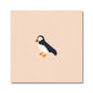 A peach square art print with a hand-printed puffin in the middle