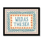 A typography print with the words WILD AS THE SEA in capital letters in watercolour deep teal in the middle on a neutral background, with 3 borders. The first being yellow scallops with deep orange dots, the second being foliage in the same colour as the typography on a pale green background and the outer being a sage wave pattern with lilac dots on a peach background, in a black frame