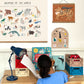 Young girl sitting at a desk colouring at a desk with aykasa crates on it storing books and accessories. Animals of the world and forever earless art prints hang over the desk in oak poster hangers