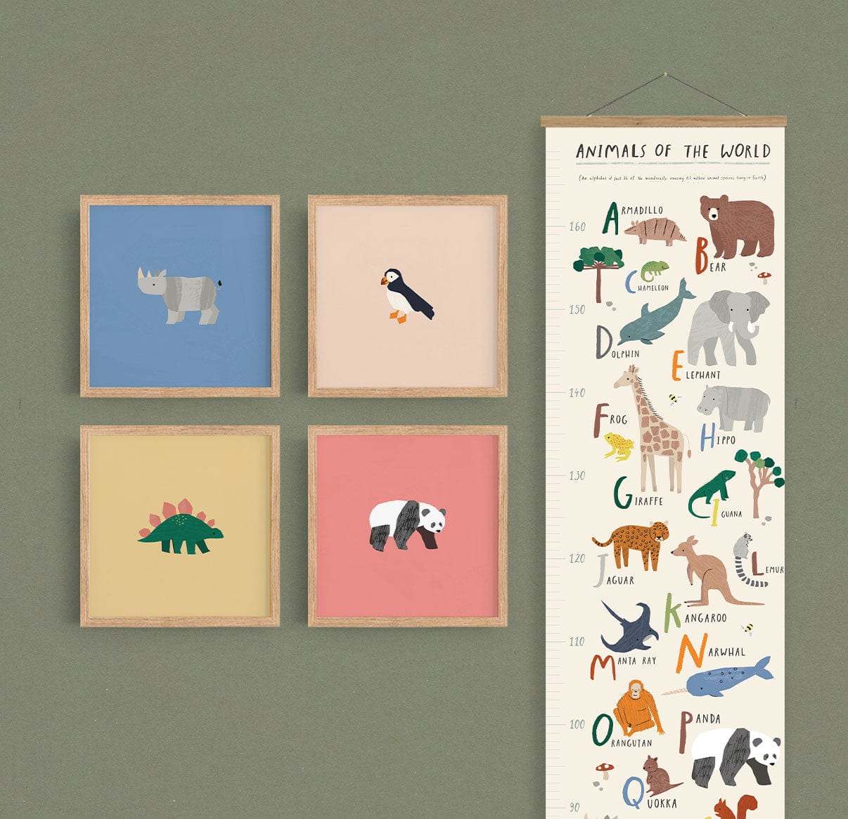 Image of a gallery wall made up of our square safari art prints, puffin, rhino, dino, and panda in natural wood frames on a green wall with our animals of the world height chart