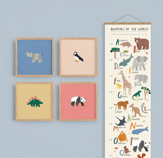 Image of a gallery wall made up of our square safari art prints, puffin, rhino, dino, and panda in natural wood frames on a sky blue wall with our animals of the world height chart