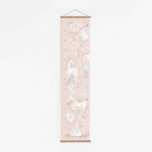 A pink height chart in a solid oak hanger, featuring delicately drawn elegant unicorns and swans in crowns. with floral and foliage detail