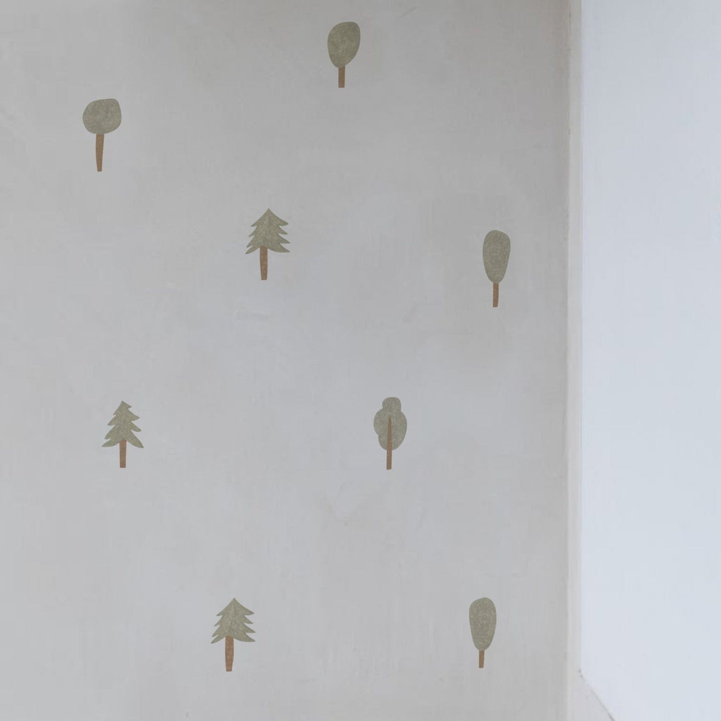 Corner of a neutrally painted room with 8 of the pencil mixed forest trees on the wall