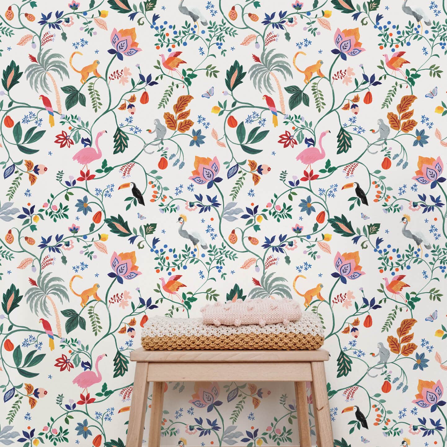 Wallpaper sample of Utopia menagerie in cream. Bright colourful animals sitting atop of exotic trees and leaves. Monkeys, Parrots, Flamingos. 