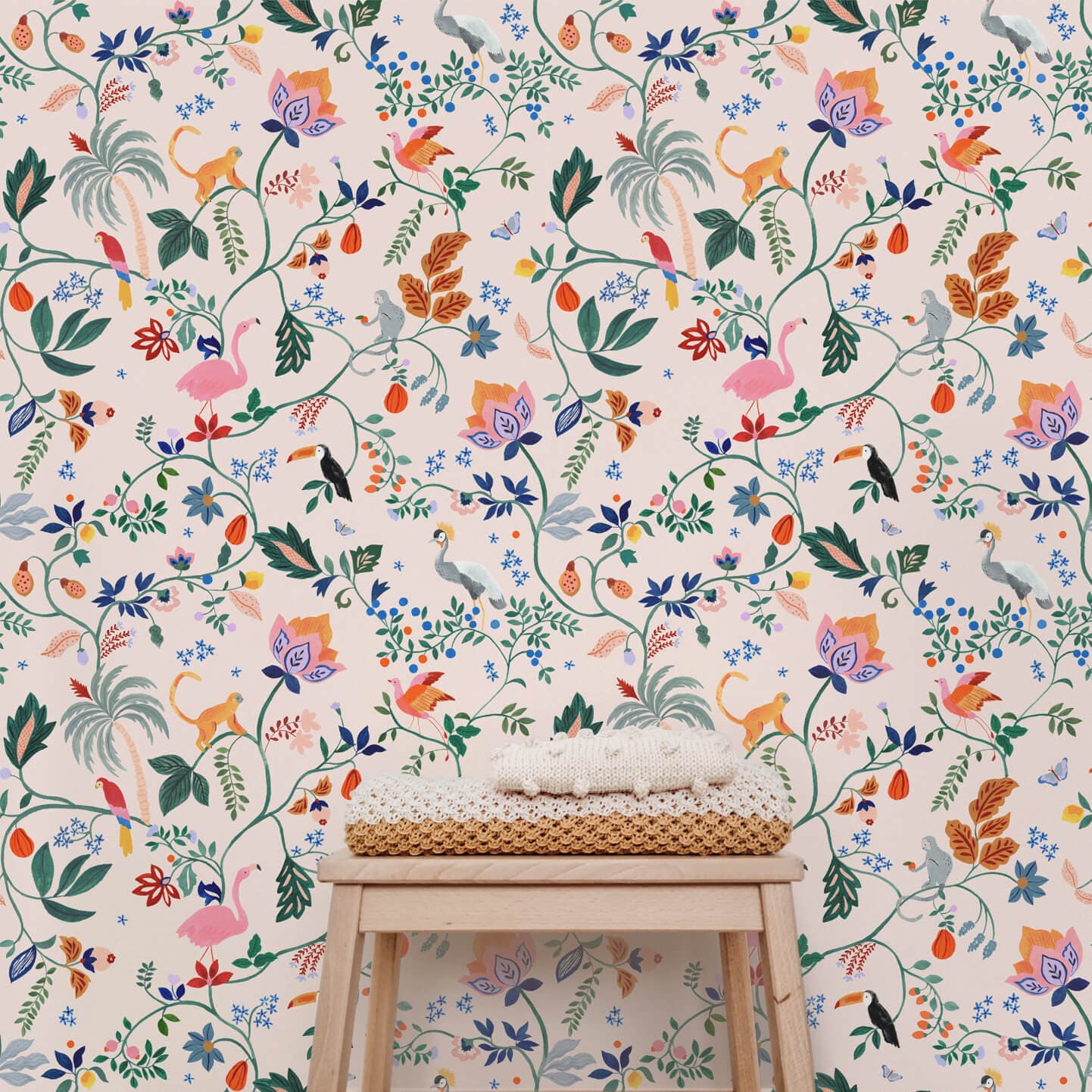 Wallpaper sample of Utopia menagerie in peach. Bright colourful animals sitting atop of exotic trees and leaves. Monkeys, Parrots, Flamingos.